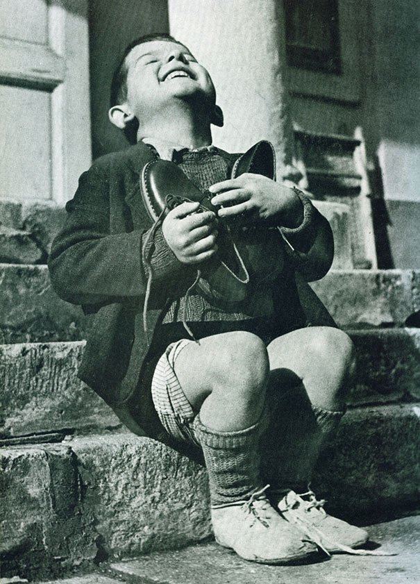 "New Shoes" by Gerald Waller, Austria 1946 Six year-old Werfel, living in an orphanage in Austria, hugs a new pair of shoes given to him by the American Red Cross.